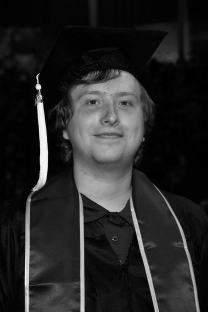 A black and white photo of Joseph Balsavich at graduation in a cap and gown